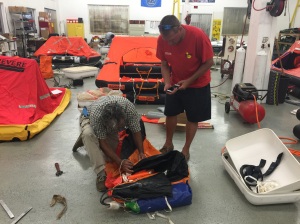 Unpacking the life raft exposes the CO2 cartridge. The cartridge is green and is about the size of a large, household-sized fire extinguisher.